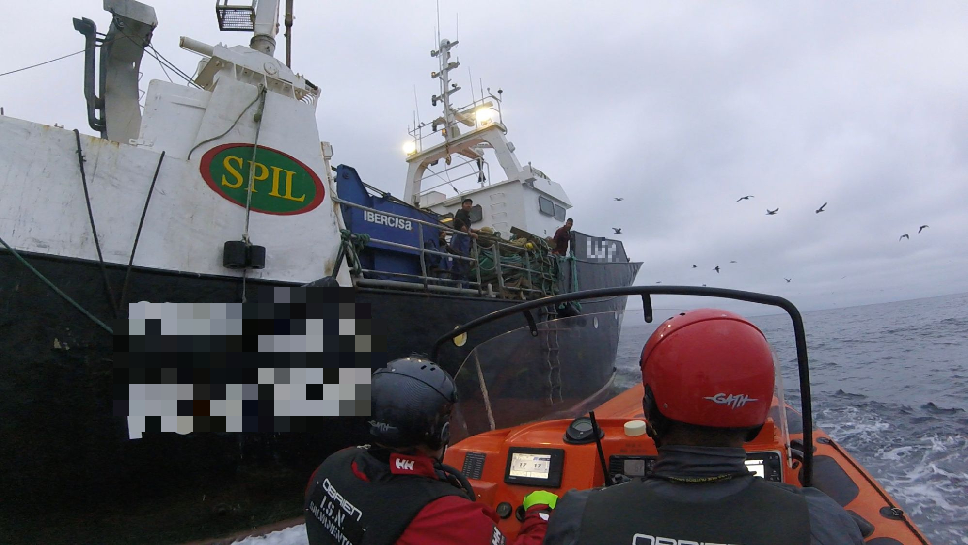 Tripulantes da Estação Salva-vidas junto à embarcação de pesca