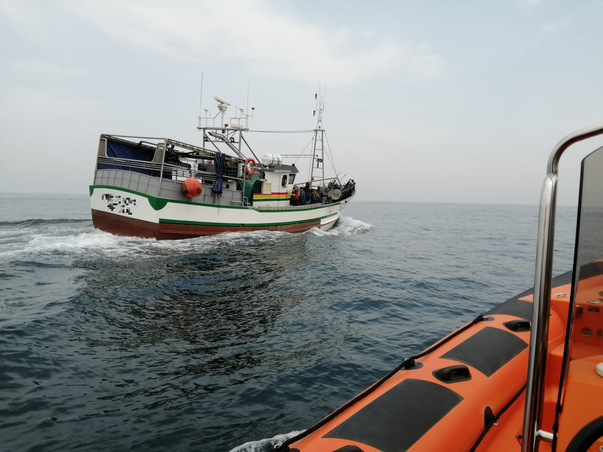Embarcação da Estação Salva-vidas junto à embarcação de pesca